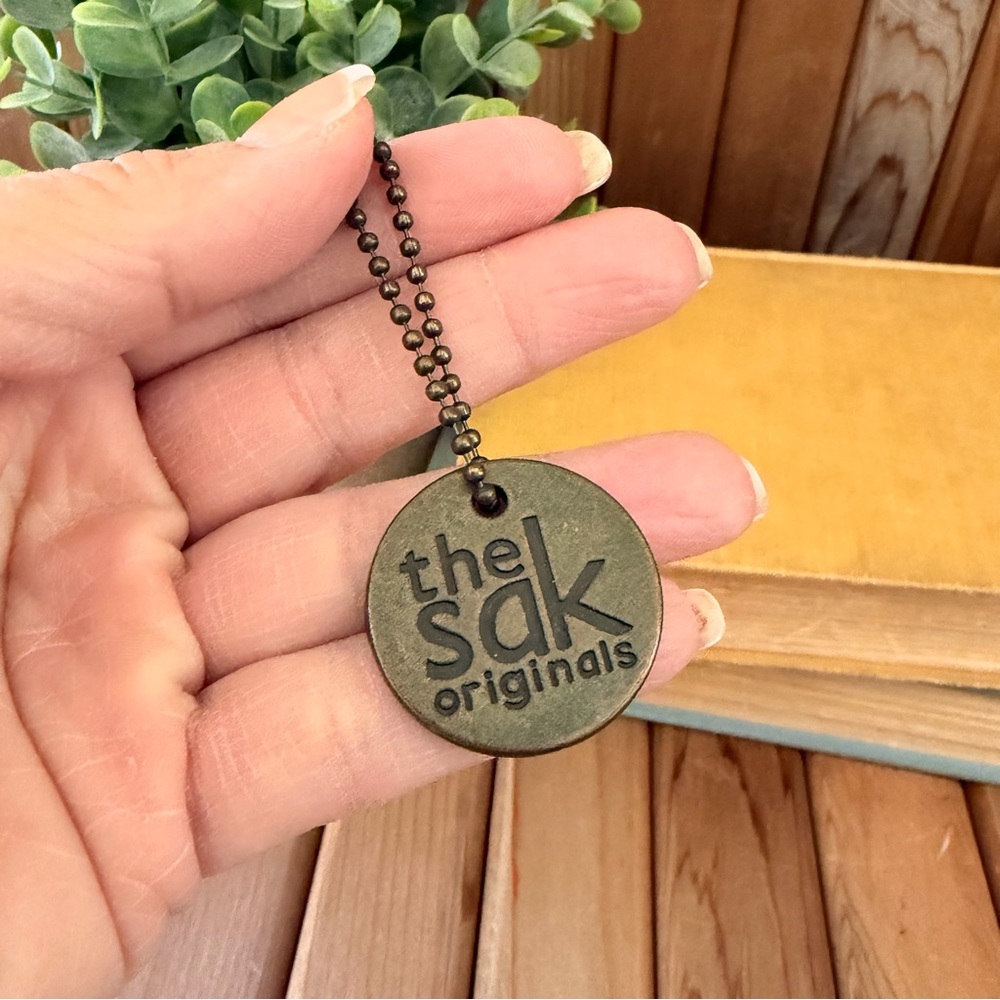 The Sak Originals Brass Logo Tag Keychain Charm Bronze Metal Minimalist